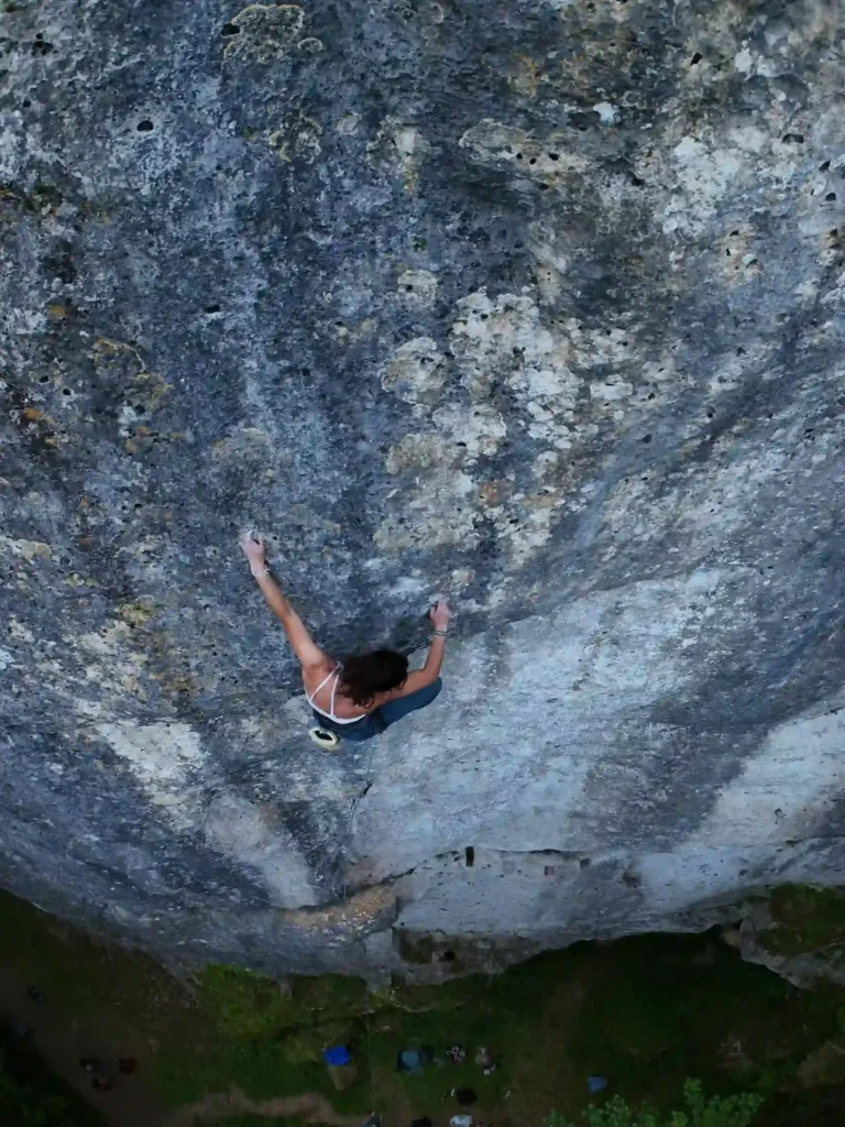 Monitrice qui grimpe sur un mur d'escalade